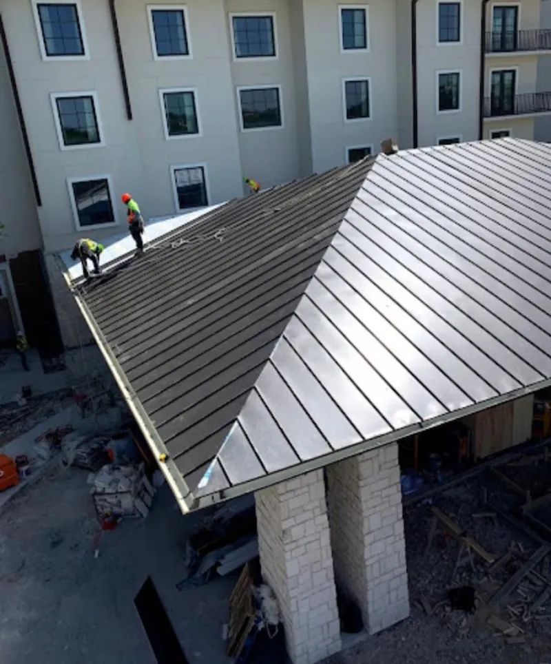 Crew installing standing seam metal roof panels on a commercial project in Jacksonville